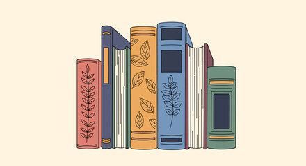 Colorful row of standing vintage books with decorative spines and botanical leaf patterns arranged on a cream colored surface.