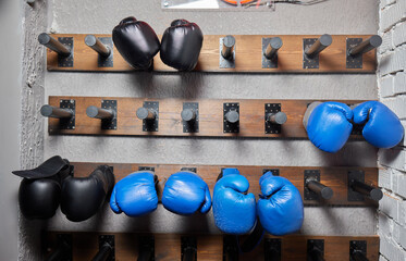 Boxing gear organized, Prepared equipment displayed neatly, Gloves systematically arranged in gym, Gym storage features lined boxing gloves in orderly environment © Евгений Вершинин