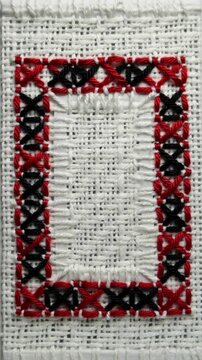 Traditional Ukrainian Embroidery Pattern Featuring Geometric Cross Stitches in Red and Black on White Fabric