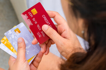Woman holding credit cards and he is choosing a credit card to pay and spend Payment for goods via credit card. Finance and banking concept
