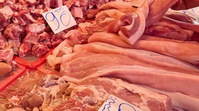 Close Up of Butcher Arranging Fresh Pork Belly on Display