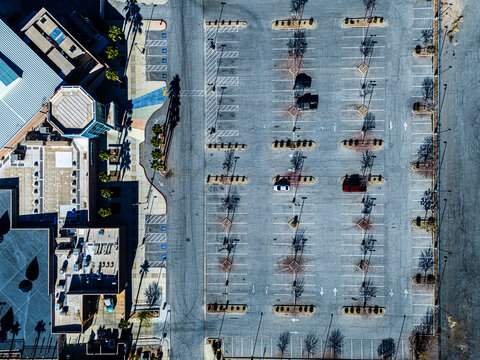 Aerial view of suburban parking area and curved access roads in Los Angeles desert environment with sparse vegetation, pedestrian crossings and urban infrastructure from above
