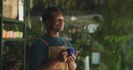 Relax, coffee and nursery with black man in store for calm, environment and sustainability. Entrepreneur, caffeine beverage and peace with person and breathing in shop for drinking herbal tea