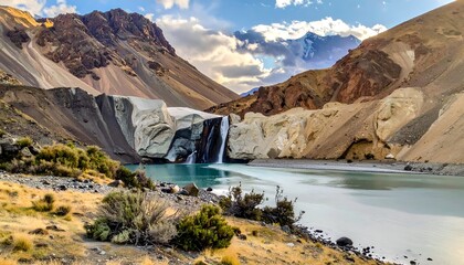 Serene mountain valley with a tiered waterfall, emerald pool, and dramatic rock formations