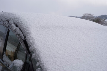 車のフロントガラスに厚く積もった新雪