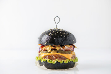 Homemade black burger with patty, cheese, bacon and salad cole slow