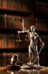 Legal Concept: Themis is the goddess of justice and the judge's gavel hammer as a symbol of law and order on the background of books