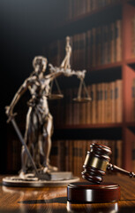 Legal Concept: Themis is the goddess of justice and the judge's gavel hammer as a symbol of law and order on the background of books