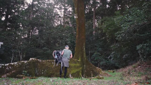 Girl hiker walking in the forest with a straw hat and a backpack in Japan