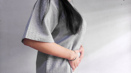 Woman holding stomach in pain, abdominal pain and stomach ache concept