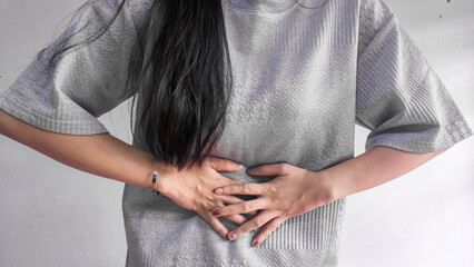 Woman holding stomach in pain, abdominal pain and stomach ache concept