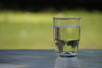 Glass of Water on Table Outdoors.