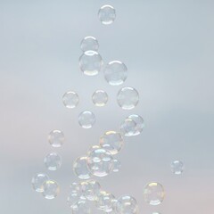 Shimmering iridescent bubbles floating against a blurred light-gray background