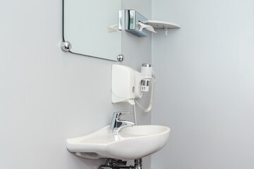Clean bathroom sink area with mirror and shelf in a modern setting