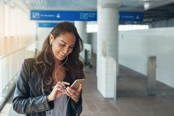 Streaming, earphones and woman in station with phone, playlist or commute with music option. Smile, song choice or female person outdoor with tech, scroll app or radio subscription for travel