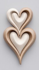 Two Intertwined Textured Heart Sculptures With Speckled Surface On Light Gray Background