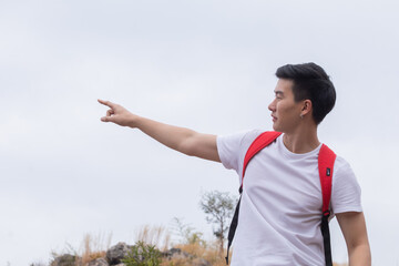 Smart Asian freelance male happy hiking walking to the top of mountain in holiday autumn vacation,...