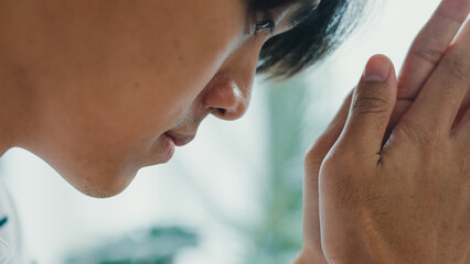 Closeup youth Asia male with casual cloth sit on sofa burnout from exam stress for education sad, headache or scare think about fail, problem in living room at house. Depression mental health concept.