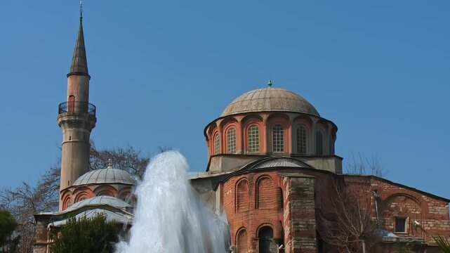 Water Flowing From a Fountain With Kariye Mosque Minaret and Dome in the Background