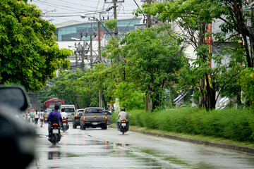 Rain water drop falling to the floor in heavy rain day. Rain in the city. Road, pavement, car in rain, close up. Water splashes.