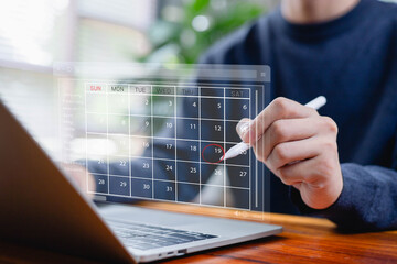 Businessman planning schedule on digital calendar interface, marking important date for meeting, deadline, or project management. Business planning, time management, productivity concept.