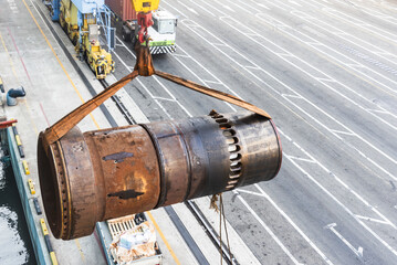 Large, used ships main engine cylinder liner discharged by the crane from the vessel to the truck in a port terminal.