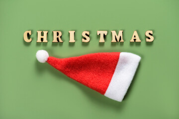 Text Christmas with red hat on green background.