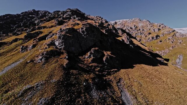 Aerial view of a FPV UAV pursuing high in the mountains on a sunny day. Tracking and pursuing a self-assembled drone.