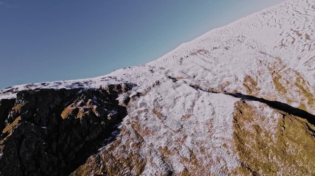 Aerial view of a FPV UAV pursuing high in the mountains on a sunny day. Tracking and pursuing a self-assembled drone.