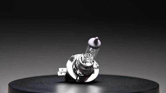 A new spare part rotates on a black gradient background. A car light bulb.