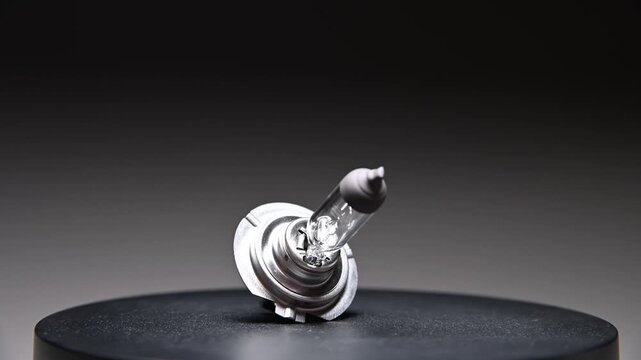 A new spare part rotates on a black gradient background. A car light bulb.