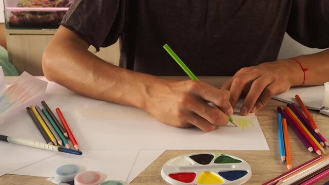 a guy draws with pencils