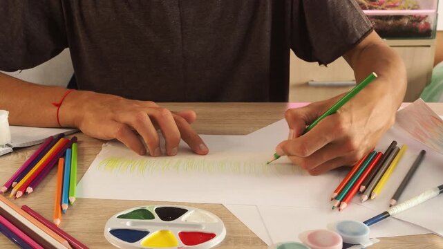 a guy draws with pencils