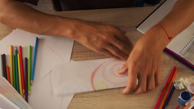 a guy draws with pencils