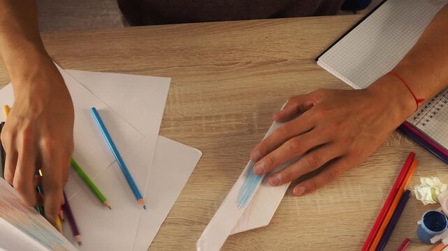 a guy draws with pencils