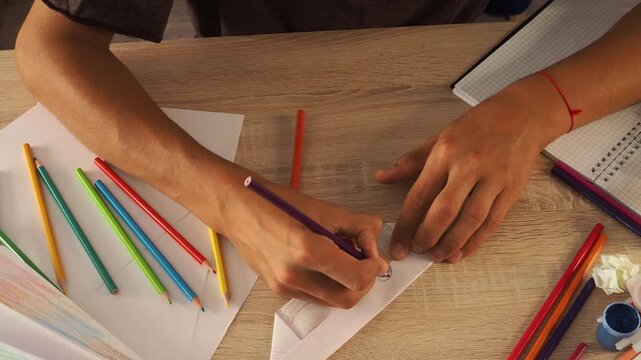 a guy draws with pencils