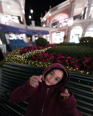 A young girl wearing a hoodie in a winter park, symbolizing affection and warmth.