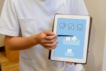 歯科医がタブレットで歯の状態を説明するシーン