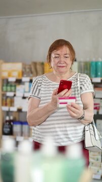 Mature woman scans code on package of paracetamol pills to check the expiration date. High quality 4k footage