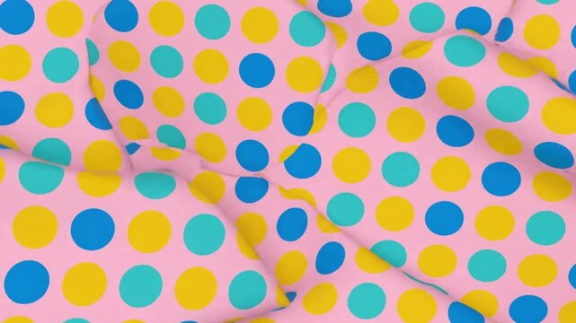 A pink fabric with a vibrant pattern of yellow, blue, and teal polka dots, showing soft folds and shadows.