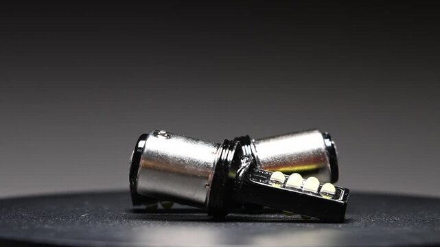 LED bulbs with different bases rotate on a gray gradient background. New parts for car interior and exterior lighting.