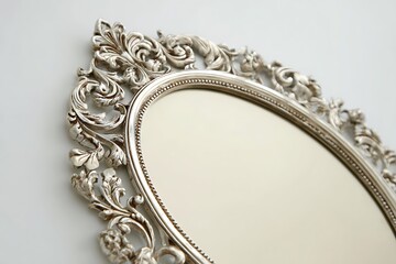 An oval mirror with intricate silver filigree design, set against a pale cream background, elegant and unique