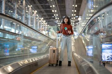 Asian young woman passenger walk in airport terminal to boarding gate. 
