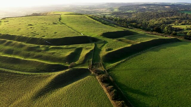 Eggardon Hill multivallate Iron Age hillfort, Dorset. Visible hut site depressions and Bronze Age linear earthworks and bowl barrow. Octagon is recent. Video fly up back from east entrance