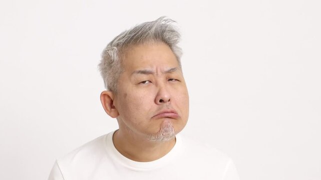 4K video of a middle-aged gray-haired man showing disbelief on white background