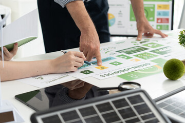 A diverse business team analyzing environmental charts and graphs in a collaborative meeting to create sustainable strategies in a modern office.