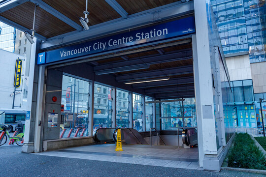 Vancouver City Centre Station entrance showing escalators descending to underground SkyTrain platform with TransLink signage