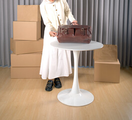 Fashionable Asian woman with large classic tan leather shoulder bag on white round table