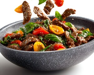 Freshly prepared beef stir fry with colorful bell peppers and basil leaves is presented in an attractive pan against a bright white background.