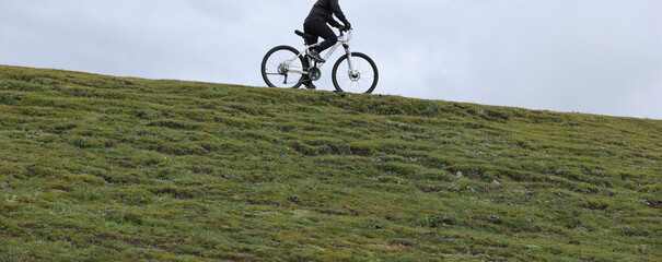 Riding mountain bike on grassland mountains